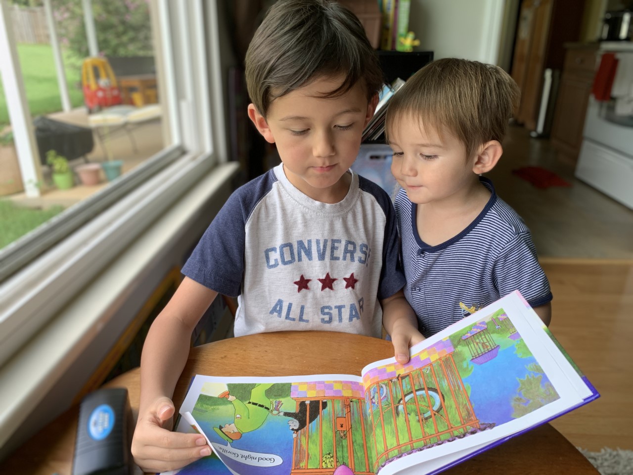 Two young boys reading book. 